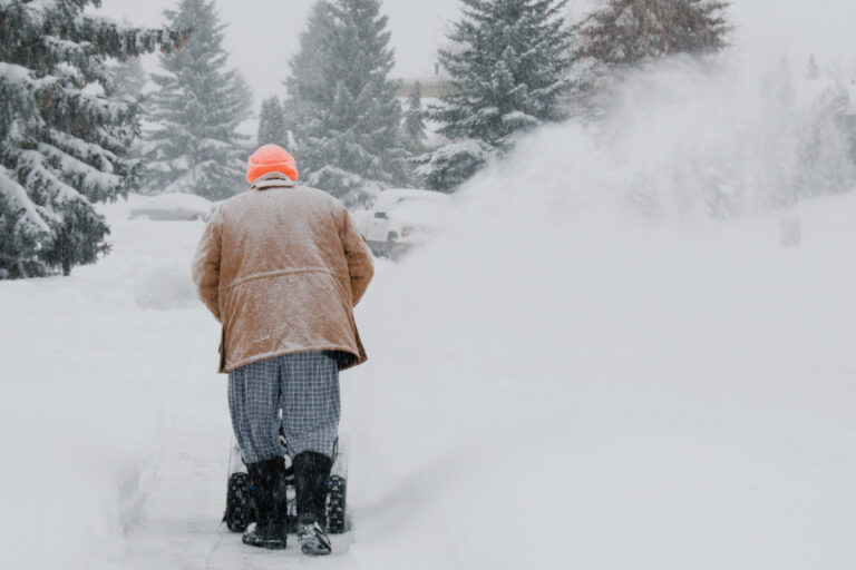 man pushing a snow blower
