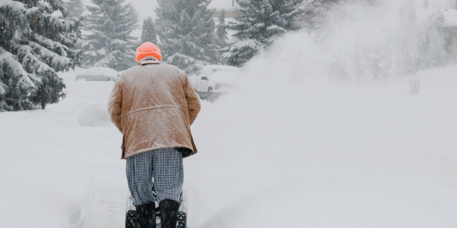 man pushing a snow blower